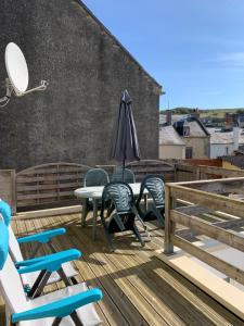 a patio with chairs and a table and an umbrella at Authentique maison de pêcheur à Port-en-Bessin in Port-en-Bessin-Huppain