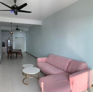 a living room with a pink couch and a table at Paddy Village Homestay in Sekincan