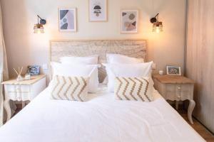 una camera da letto con un letto bianco con lenzuola e cuscini bianchi di L19 1BDR Massena central 2mins Sea/PromenadeAC/Balcony a Nizza