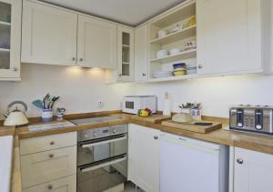een keuken met witte kasten en witte apparaten bij 4 Blackshore in Southwold