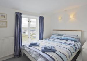 een slaapkamer met een bed met blauwe handdoeken bij 4 Blackshore in Southwold