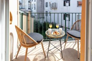 un balcone con 2 sedie e un tavolo con 2 bicchieri di vino di L19 1BDR Massena central 2mins Sea/PromenadeAC/Balcony a Nizza