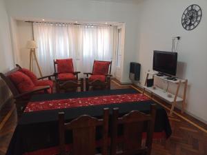 - un salon avec une table, des chaises et une télévision dans l'établissement Arenas MDQ, à Mar del Plata