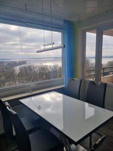 einen Konferenzraum mit einem Tisch, Stühlen und Fenstern in der Unterkunft Plön - Traumhafter Seeblick in Plön