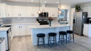 eine Küche mit weißen Schränken und eine blaue Insel mit Barhockern in der Unterkunft Brand New 2 Bedroom Cottage on Seneca Lake in Himrod