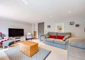 a living room with two couches and a flat screen tv at 5 River Lane in Halesworth