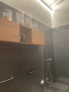 a bathroom with a shower with a shelf on the wall at Garda Golf Country Chic Home in Soiano del Lago