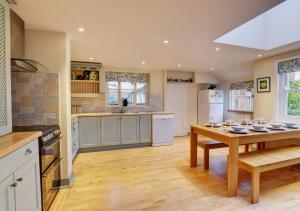 4 Doric Place في وودبريدج: مطبخ كبير مع طاولة خشبية وغرفة طعام