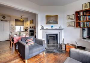 a living room with a couch and a fireplace at 6 Coastguard Cottages in Hollesley