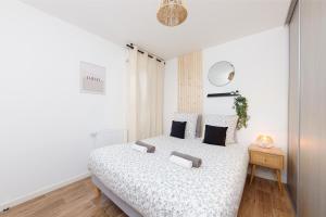 Dormitorio blanco con cama y mesa en Le Panorama - chaleureux et cosy - Proche Bordeaux, en Lormont