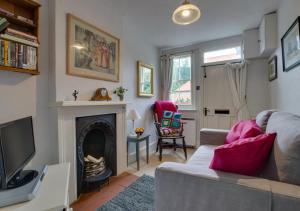 a living room with a couch and a fireplace at 9 Gate Cottage in Long Melford