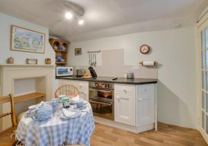 uma cozinha com uma mesa e uma bancada em 9 Gate Cottage em Long Melford