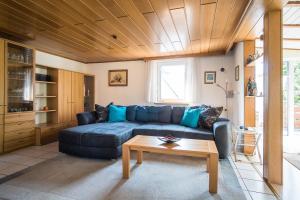 a living room with a blue couch and a table at Ferienwohnung Schmid in Tübingen
