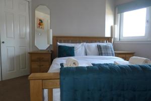 une chambre avec un grand lit avec une couverture bleue dans l'établissement Aigas Cottage, à Glasgow