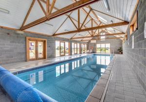 a swimming pool in a house with a ceiling at Amrose Cottage in Blythburgh