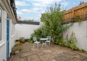 a patio with a table and chairs in a garden at Anchor Cottage in Woodbridge