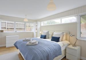 a bedroom with a bed with blue and white sheets at Arva in Southwold