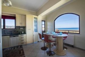 cocina con mesa y vistas al océano en Terpsis House en Kissamos
