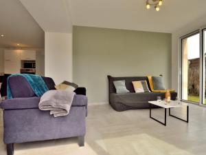 een woonkamer met twee banken en een tafel bij Holiday Home Les Volets Bleus by Interhome in La Turballe