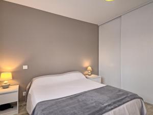 een slaapkamer met een wit bed en twee nachtkastjes bij Holiday Home Les Volets Bleus by Interhome in La Turballe +20 foto's