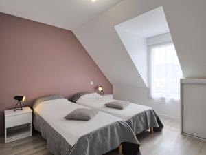 twee bedden in een witte kamer met een raam bij Holiday Home Les Volets Bleus by Interhome in La Turballe