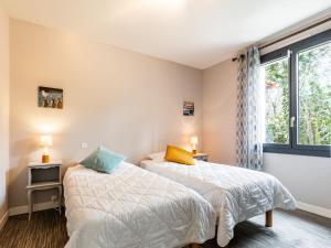 two beds in a room with a window at Holiday Home Les Narcisses by Interhome in Ronce-les-Bains