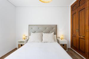 een slaapkamer met een wit bed en 2 nachtkastjes bij EDEN RENTALS Kings Kapital in Santa Cruz de Tenerife