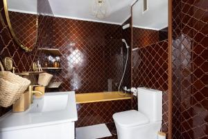 een badkamer met een toilet, een wastafel en een spiegel bij EDEN RENTALS Kings Kapital in Santa Cruz de Tenerife
