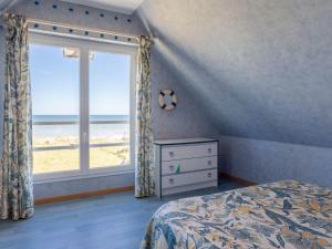サン・ローラン・シュル・メールにあるHoliday Home Chez Lilo by Interhomeのベッドルーム1室(ベッド1台付)、ビーチを望む窓が備わります。