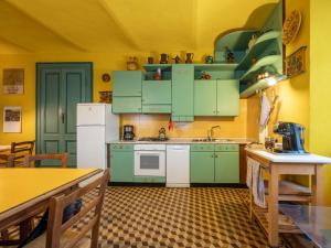 Cossano BelboにあるHoliday Home La Rovere by Interhomeの黄色の壁のキッチン(緑のキャビネット付)
