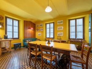 a yellow room with a table and chairs and windows at Holiday Home La Rovere by Interhome in Cossano Belbo