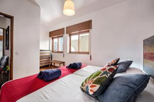 - une chambre avec un grand lit et des oreillers dans l'établissement Sea Star Apartments - Casa Verde e Casa Azul, à Armação de Pêra