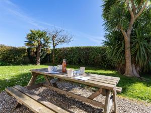 - une table de pique-nique en bois avec une bouteille et des boissons dans l'établissement Holiday Home La Ferme du Manoir by Interhome, à Réville