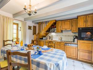een keuken met een tafel met een blauw en wit tafelkleed bij Holiday Home Keranna - LPM102 by Interhome in Lampaul-Ploudalmézeau