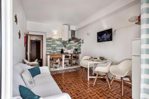a living room with a white couch and a table at Sea Star Apartments - Casa Verde e Casa Azul in Armação de Pêra