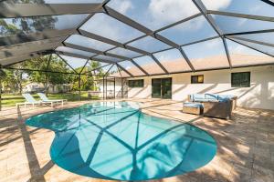 a large swimming pool with a glass roof at Indies Pool Paradise in Jupiter