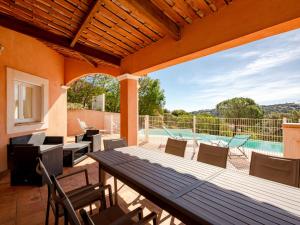 a patio with a table and chairs and a swimming pool at Villa La Figuière by Interhome in La Nartelle