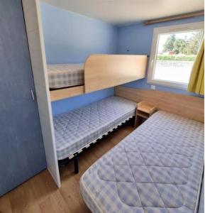 ein kleines Zimmer mit 2 Etagenbetten und einem Fenster in der Unterkunft DOMAINE DE LA GRANGE DES CHAMPS in Lorris