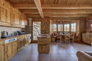 uma cozinha com armários de madeira e uma mesa num quarto em Chalet Mandalay em La Tzoumaz