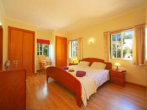 a bedroom with a large bed and two windows at Holiday Home Montinho by Interhome in Loulé