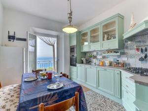 a kitchen with green cabinets and a table with a plate on it at Apartment Al Tramonto by Interhome in Portoferraio