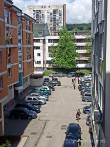 een parkeerplaats vol auto's in een stad bij Apartman Tovilovic in Doboj