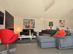 a living room with a couch and a red chair at Holiday Home Villa Noalou by Interhome in Arzon +30 photos