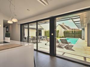 a kitchen with sliding glass doors leading to a patio at Holiday Home Villa Noalou by Interhome in Arzon