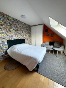 a bedroom with a large white bed and a couch at LES TEMPS HEUREUX exclusivement Familles in Quimper