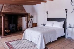 a bedroom with a large bed and a fireplace at Casa do Lume in Leiria