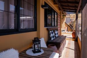 - une terrasse couverte avec un banc en bois et des fenêtres dans l'établissement Casa do Lume, à Leiria