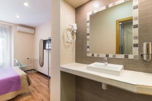La salle de bains est pourvue d'un lavabo, d'un lit et d'un miroir. dans l'établissement Hostal Art Madrid, à Madrid