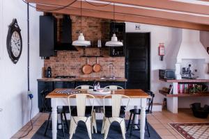 a kitchen with a table and chairs and a clock at Casa do Lume in Leiria