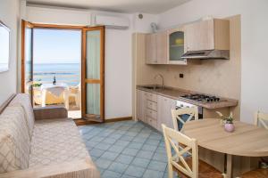 una cucina e una sala da pranzo con vista sull'oceano di Residence Buganvillea ad Alghero